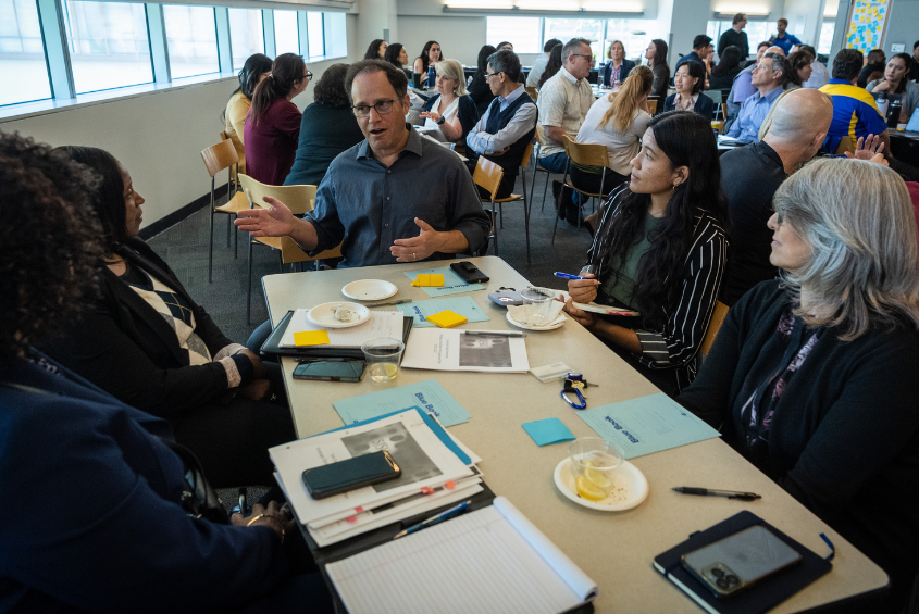 Staff members at a table discussing something.