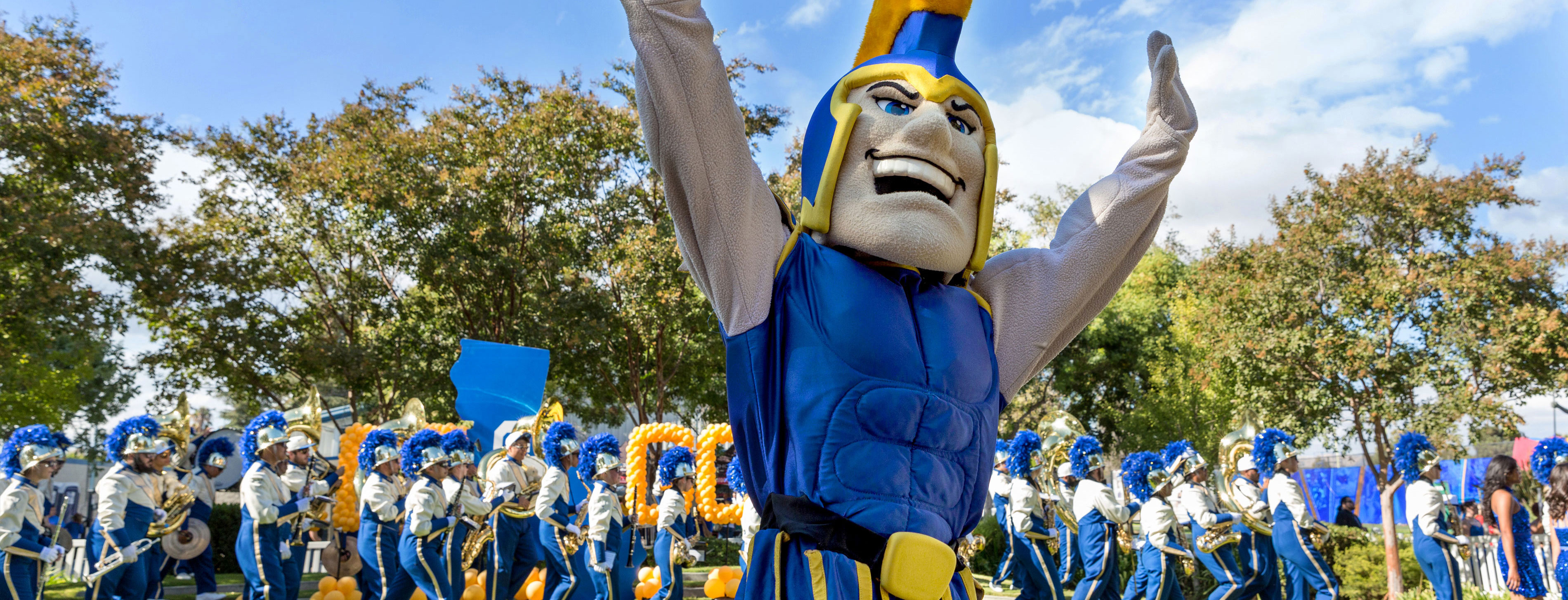 sammy spartan cheering in front of marching band