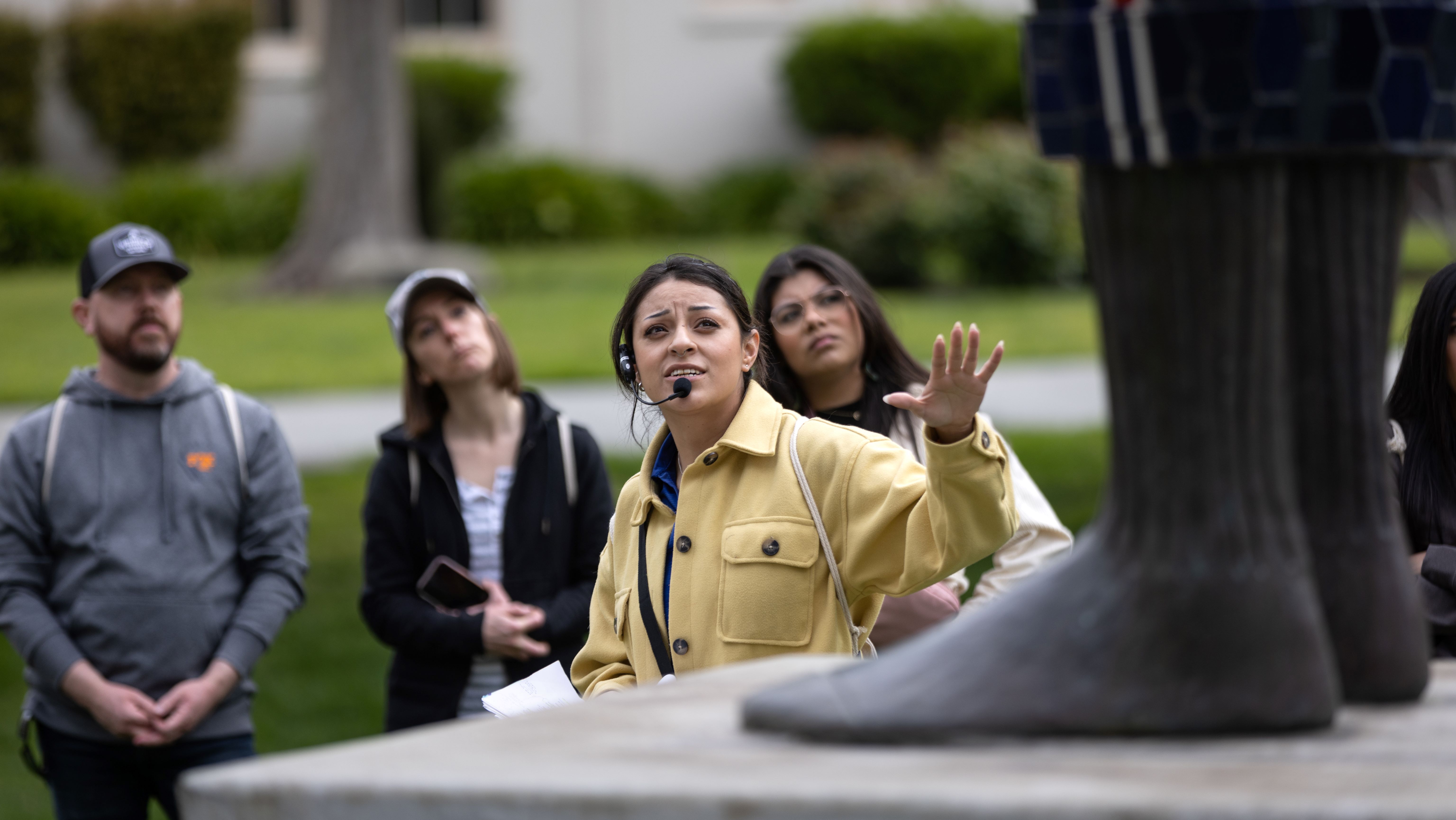 Student ambassador wearing a headset leading tour group on campus
