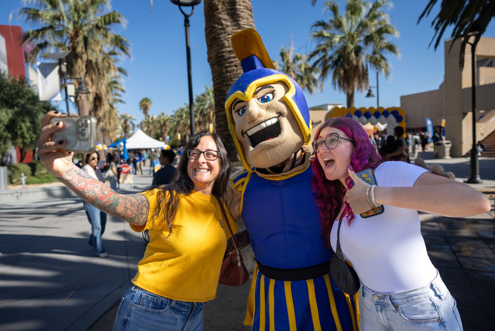 Sammy poses for a selfie with two people