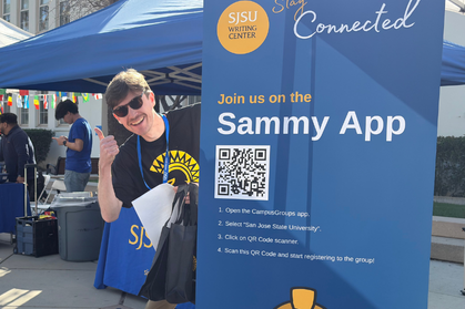Tutor wearing sunglasses peaking from behind a banner and with a thumbs up gesture