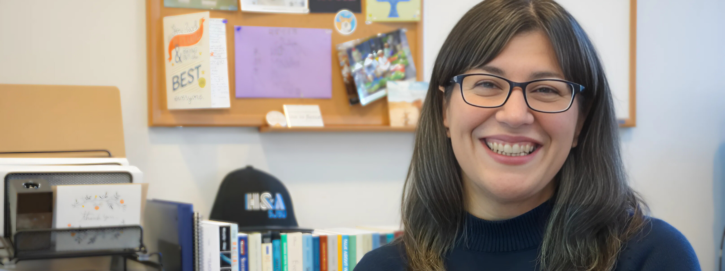 Writing Center director sitting at desk smiling