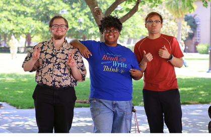 Three tutors standing on lawn and smiling